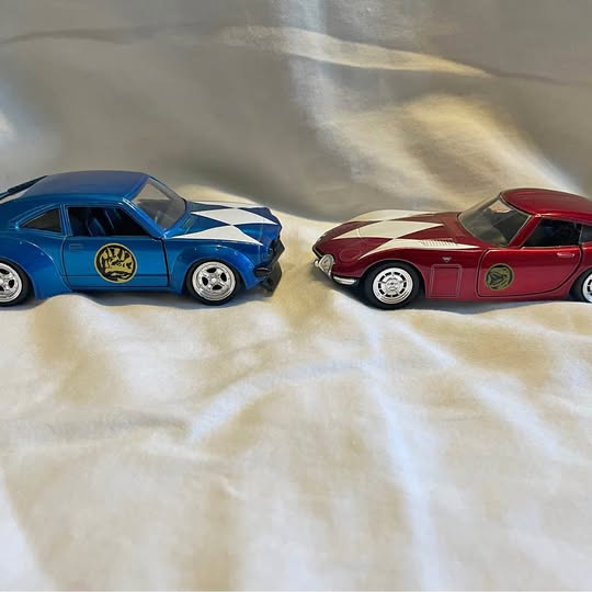 Blue and red diecast Power Ranger toy cars, front three-quarter view