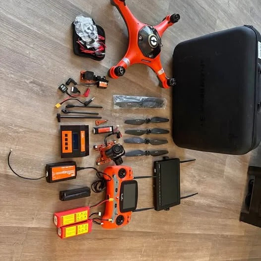 Waterproof orange drone kit with waterproof case, controller, and spare parts
