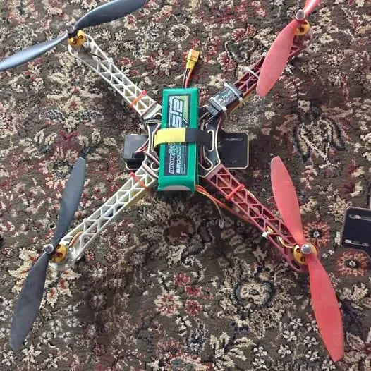 Quadcopter drone with four pink propellers and green controller board, top view