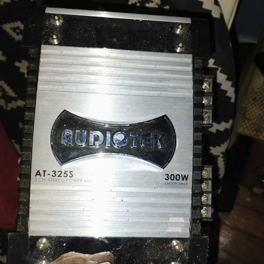 Metallic silver electronic power amplifier with black housing and branding