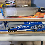 Blue diecast race car hauler with Pfizer branding and two race cars