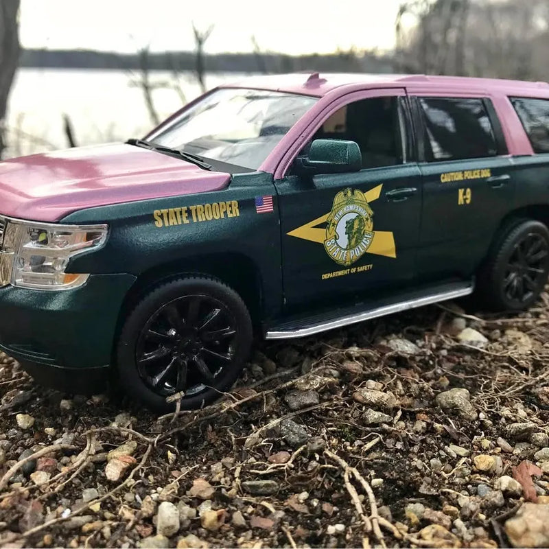 Police diecast toy car, dark green body with pink hood and side decals