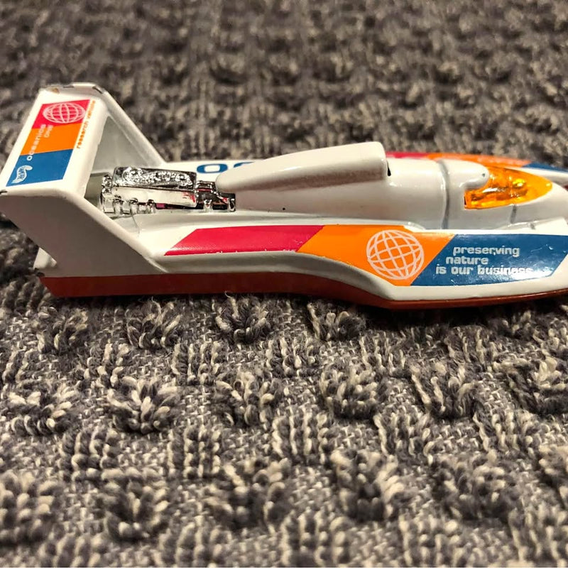 Diecast hydroplane toy boat in white with blue and orange accents, side view with cockpit