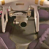 Compact drone with four legs and front camera sensor, light gray body