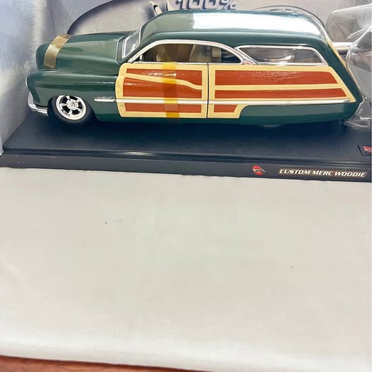 Green vintage diecast car with orange racing stripes and chrome wheels