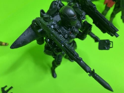 Dark green armored action figure with helmet and large rifle, pose facing left