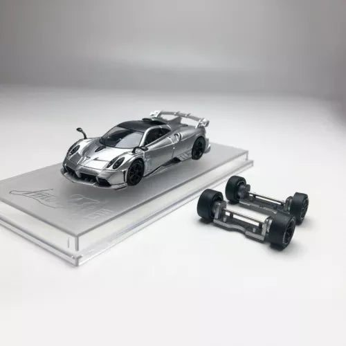 1/64 scale diecast sports car model, silver with black accents, on base with spare parts
