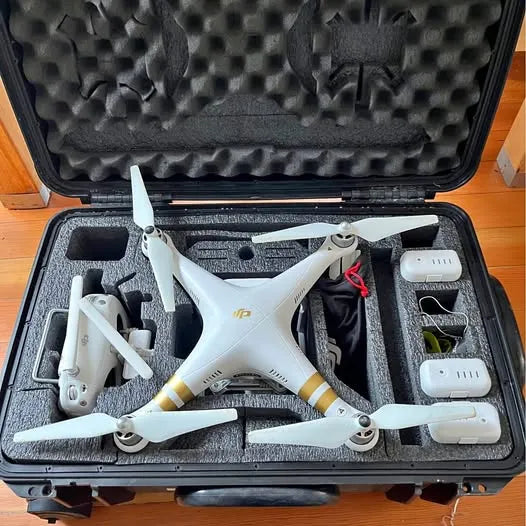 White quadcopter drone in hard case with foam inserts and charging accessories