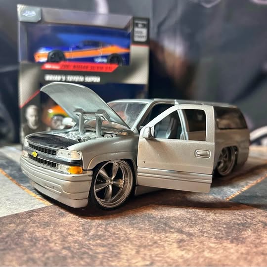 Gray diecast SUV with open hood, black wheels, front three-quarter view, steering detail