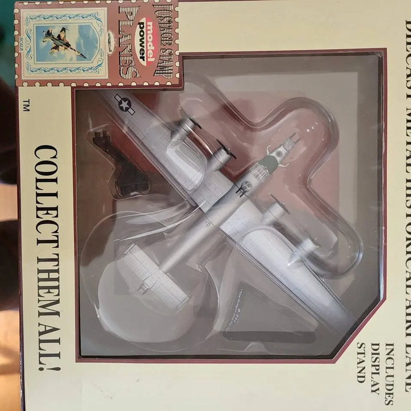 Silver gray diecast airplane model with propeller, shown in retail display box