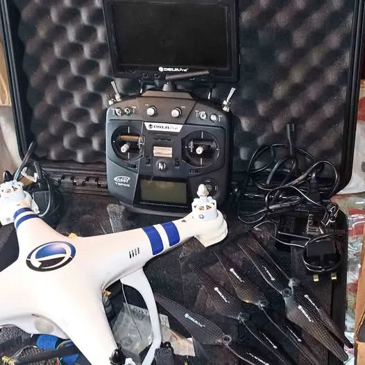 White quadcopter drone with remote controller and folded propellers in hard case