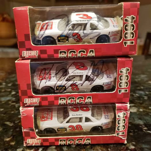 Three boxed NASCAR diecast cars with signed white cars and red checkered RCCA branding