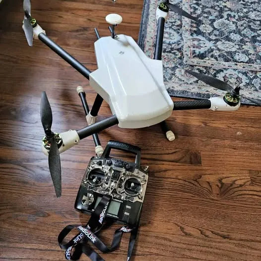 White quadcopter RC drone with four propellers and remote controller