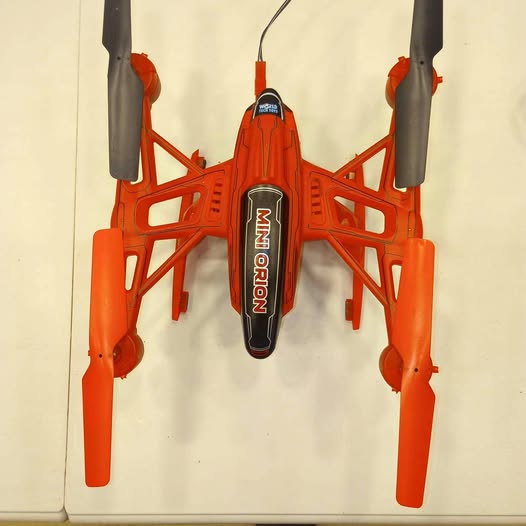 Orange quadcopter drone with four propeller arms and central control module