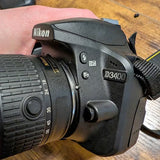 Nikon D3400 DSLR camera with attached lens, textured grip and D3400 badge