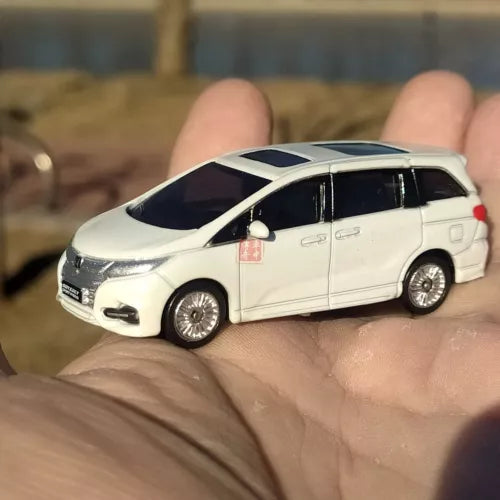 White 1:64 diecast minivan model car with black windows, side view, detailed wheels