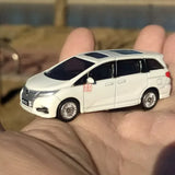 White 1:64 diecast minivan model car with black windows, side view, detailed wheels