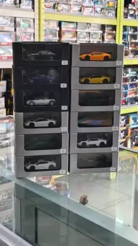 Diecast car toy set with multiple boxed models in a display case, varied colors