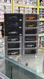 Diecast car toy set with multiple boxed models in a display case, varied colors