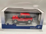 Red 1:18 scale diecast model car in display box, with detailed wheels and decals