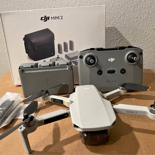 Foldable quadcopter drone with white body and black controller, with accessories