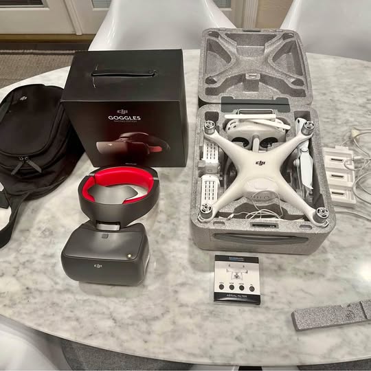 Folding drone kit with white drone and red/gray goggles in a molded case