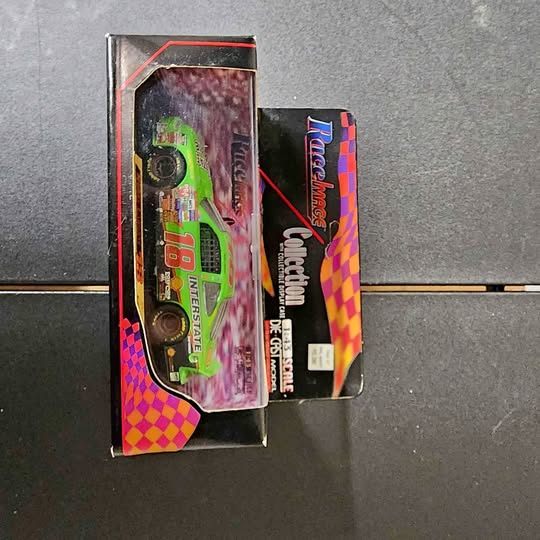 Diecast car in retail box, neon green vehicle with checkered graphics