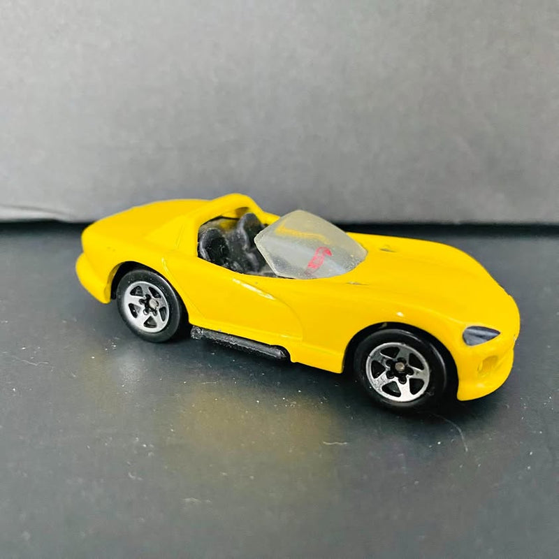 Yellow vintage sports car diecast with black wheels and clear windshield