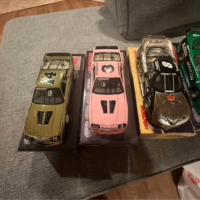 Set of four diecast race cars on a display tray, front views