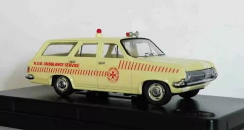 Yellow diecast ambulance model car with red NSW service markings and front grille