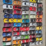 Diecast car collection with assorted miniature cars in multiple colors, top view.