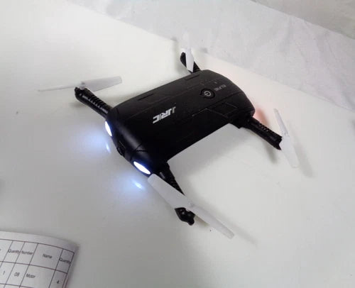 Black foldable quadcopter drone with front lights and four rotors