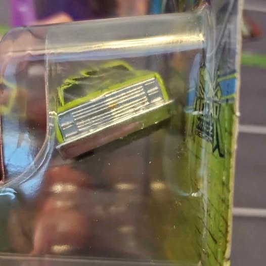 1:64 diecast truck in clear box, green body with yellow hood panel