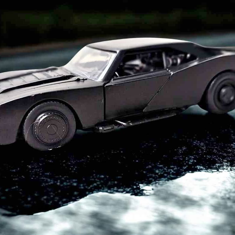 Batmobile diecast metal toy car, dark gray body with detailed wheels and cockpit.