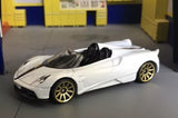 White diecast roadster car with black cabin and gold spoke wheels, front three-quarter view.
