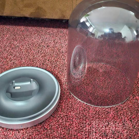 Gray charging display case with open circular lid and inner stand