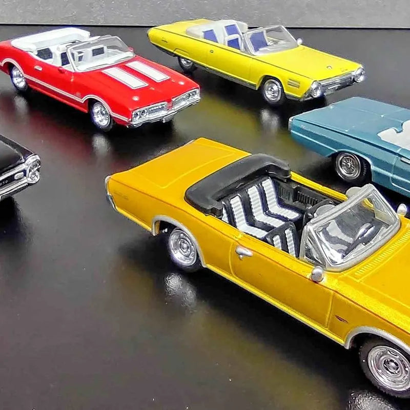 Diecast model car: yellow convertible with open hood, chrome wheels, detailed grille