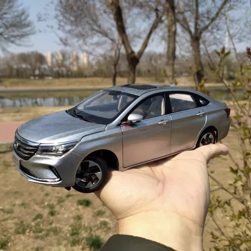 Silver 1:18 scale sedan diecast model with black wheels, detailed front and side.