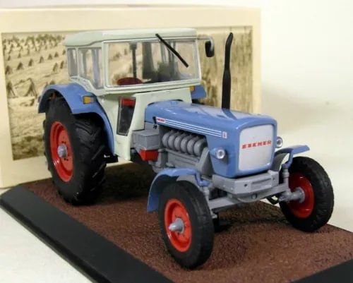 Blue and white diecast tractor model with red wheels, cab, and exhaust stack