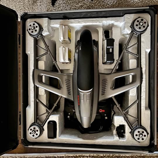Foldable 4K drone in hard case, with central camera body and four propeller arms