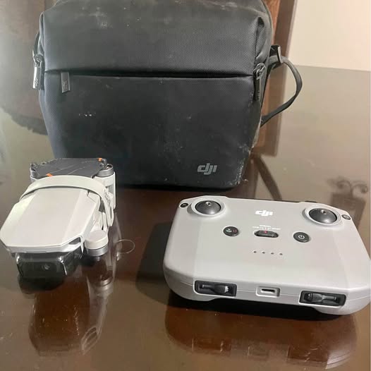 DJI mini drone with controller and carrying pouch, on a tabletop