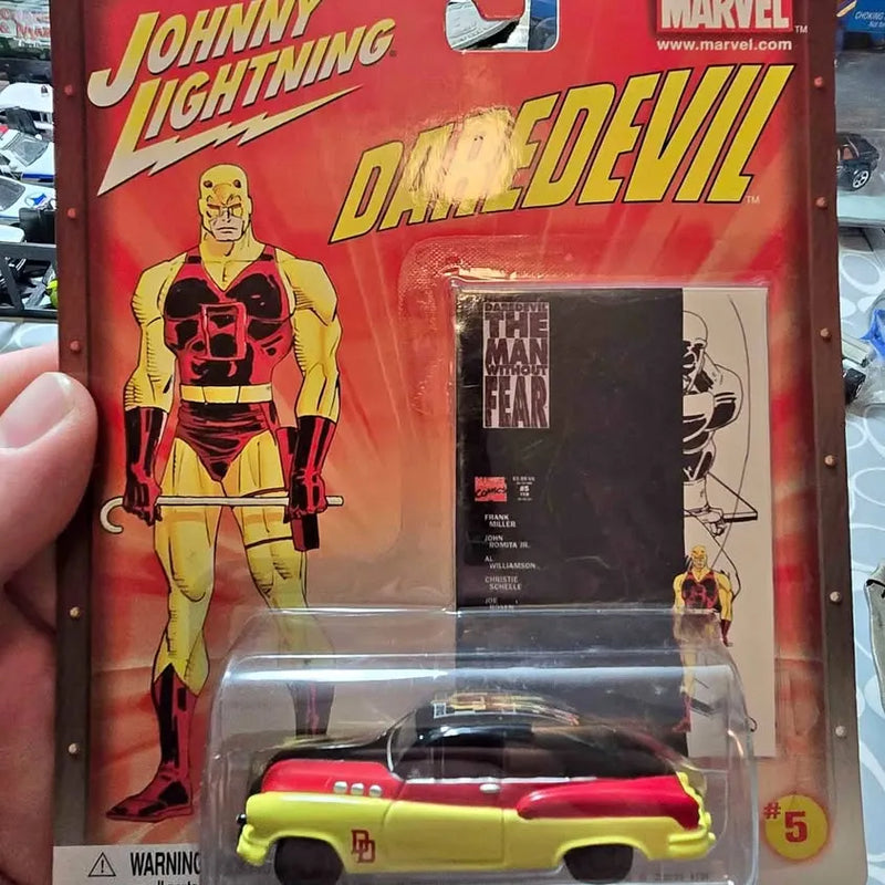 Johnny Lightning diecast model car, yellow and red, in clear blister packaging