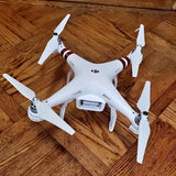 DJI Phantom 3 drone, white quadcopter with four propellers and mounted camera