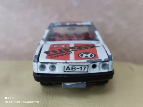 Vintage toy diecast car, front view, blue and white with red logo and headlights