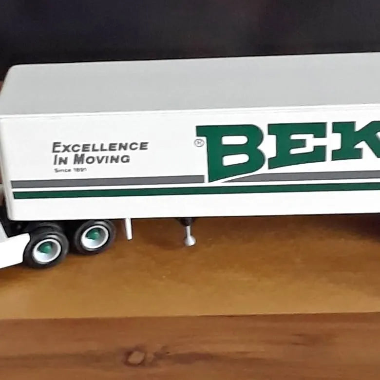Diecast semi truck with white trailer and green logo, rear wheels visible