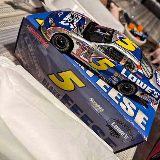 Diecast race car in blue retail box with yellow number 5 and driver graphics