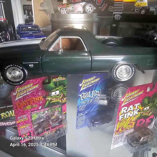 Green diecast classic car with spinning wheels, shown with Johnny Lightning Rat Fink boxes