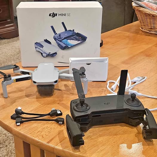 DJI Mini SE drone with remote controller and charging cable, accessories laid out