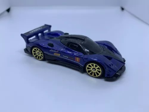 Blue sports car diecast model with black hood and yellow rims, 1:64