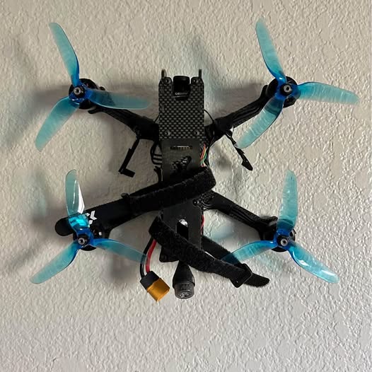 FPV quadcopter drone with black frame and four light blue propellers
